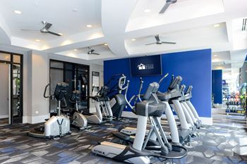 A gym with various exercise equipment in the lobby of a building